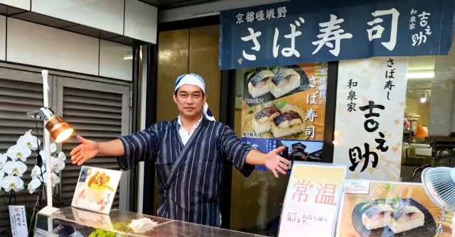 店舗の前で迎える店主